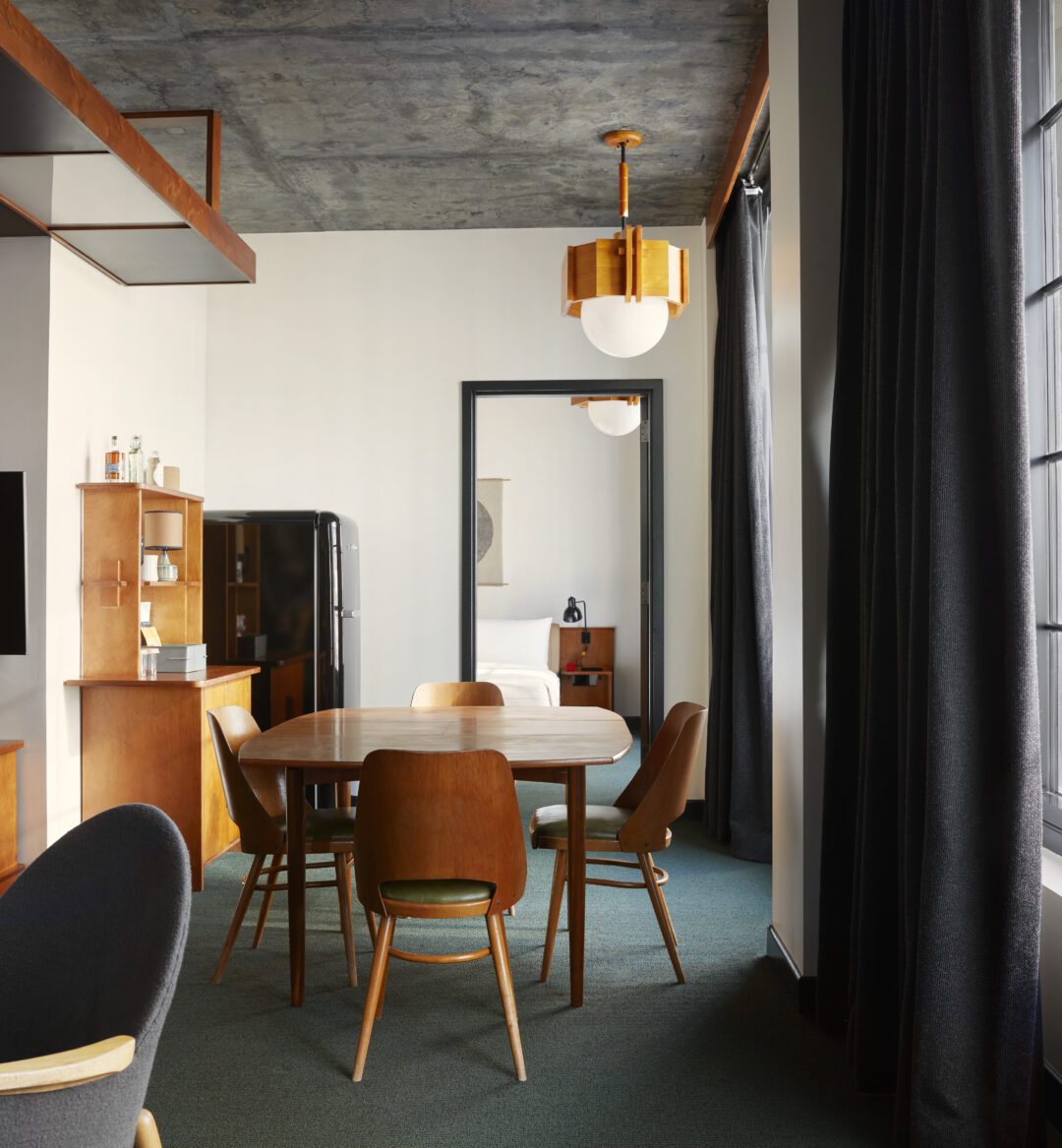 A table with 4 chairs sits between the bedroom and living room area
