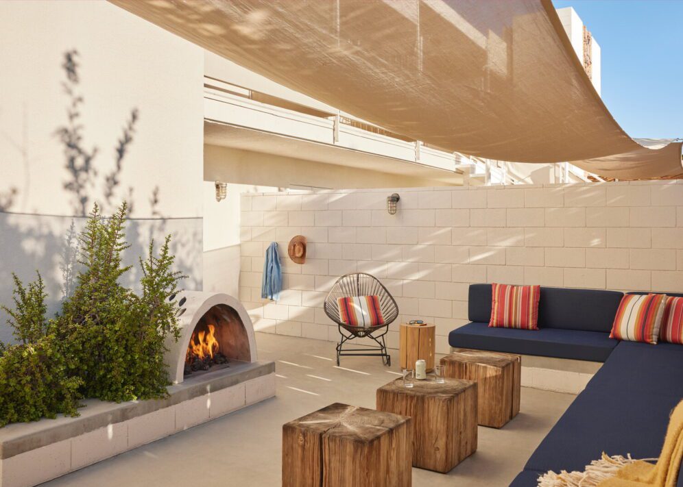 A long blue couch sits across from a fireplace, providing a large amount of seating and privacy