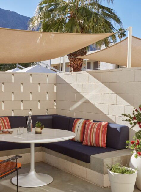 A private patio provides a sofa, table, and chair for outdoor relaxation; a wooden gate provides access to the rest of the outdoors