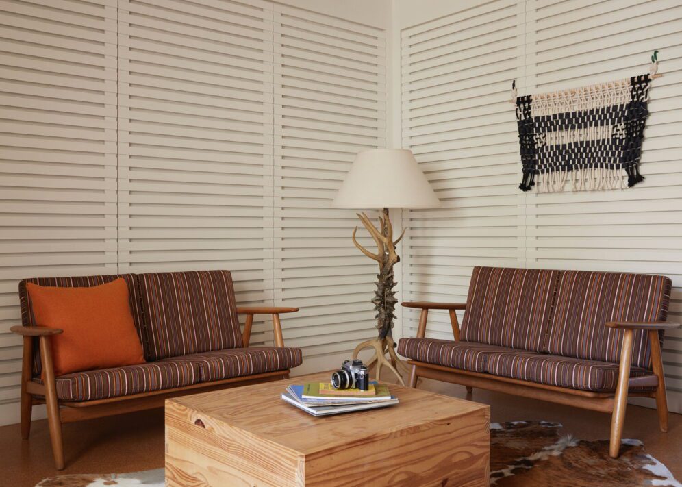 A sitting area in the corner features two couches, a coffee table with reading material, and an ornate lamp