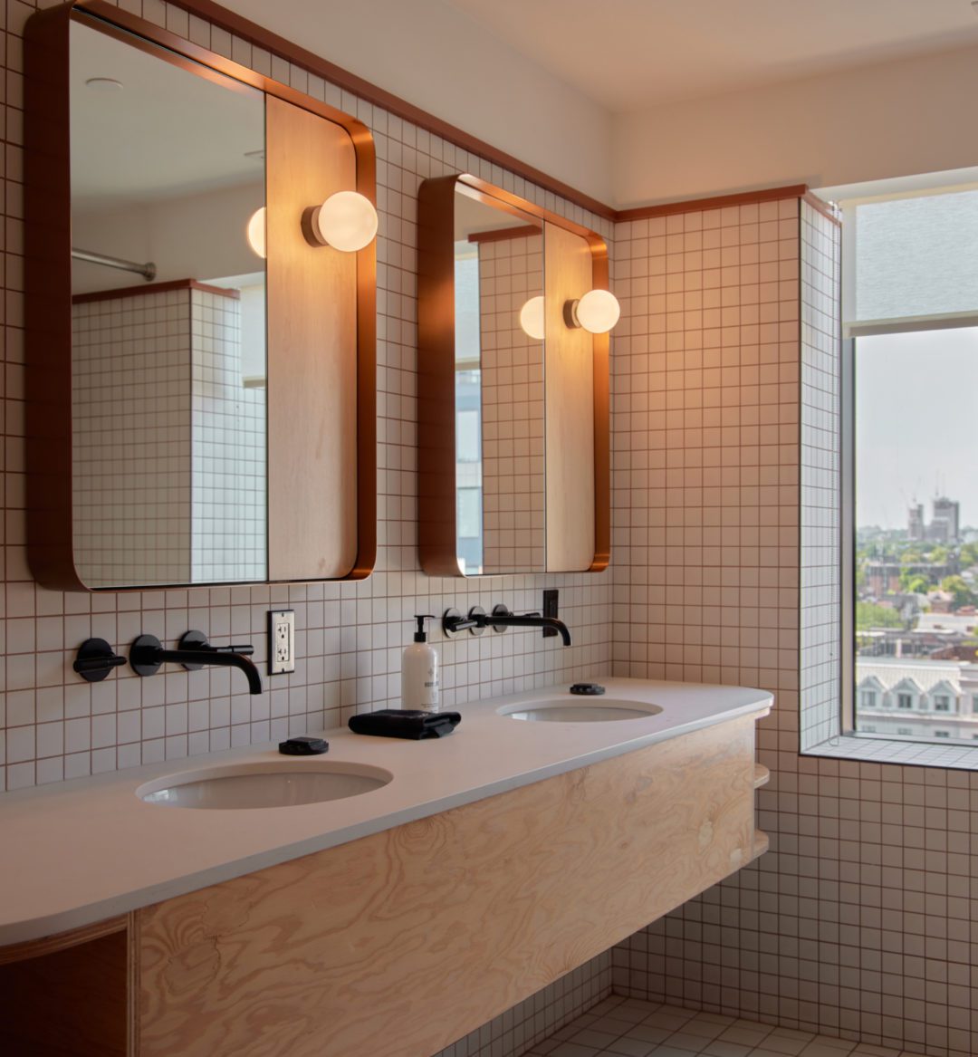 Two vanity areas include sinks and well lit mirrors for two people to prepare simultaneously